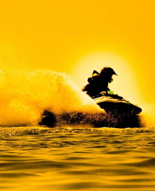 man drive jet ski at sunset.